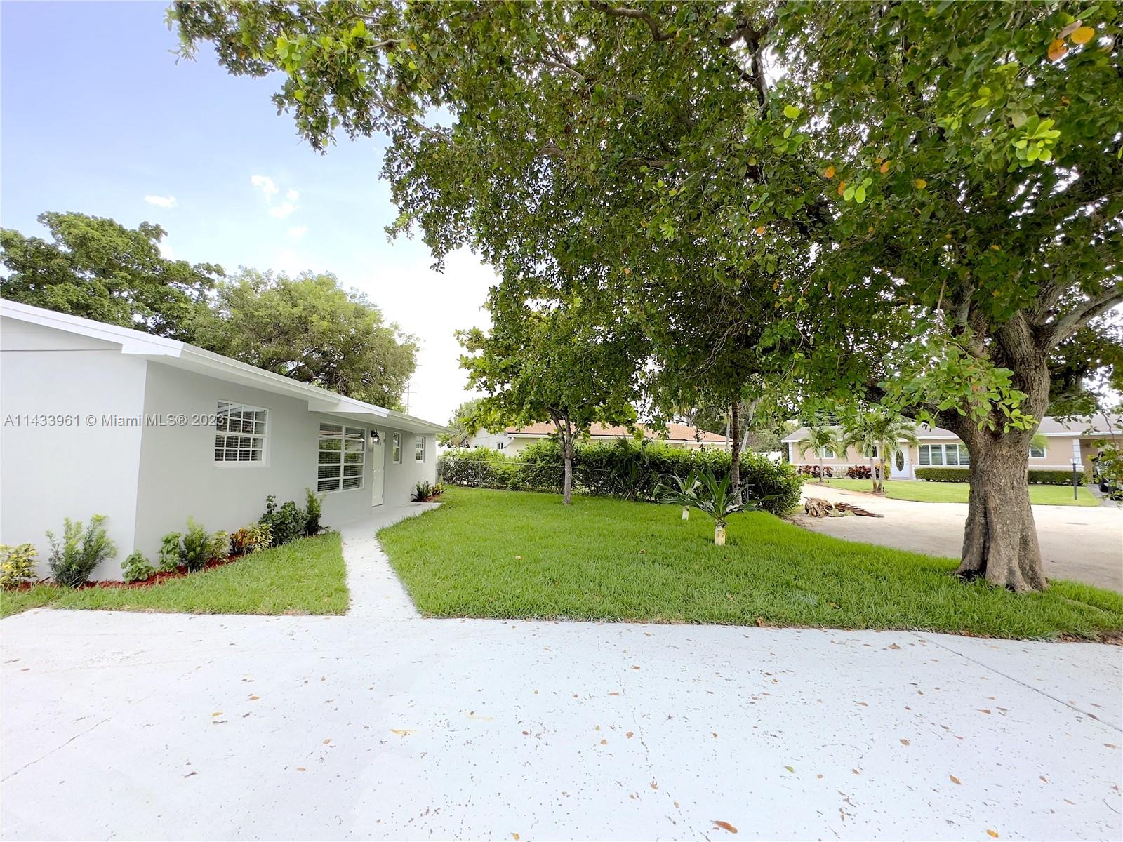 1460 Southwest 3rd Terrace Deerfield Beach, FL 33441 - Photo 3 of 100 a view of a backyard with plants and large tree