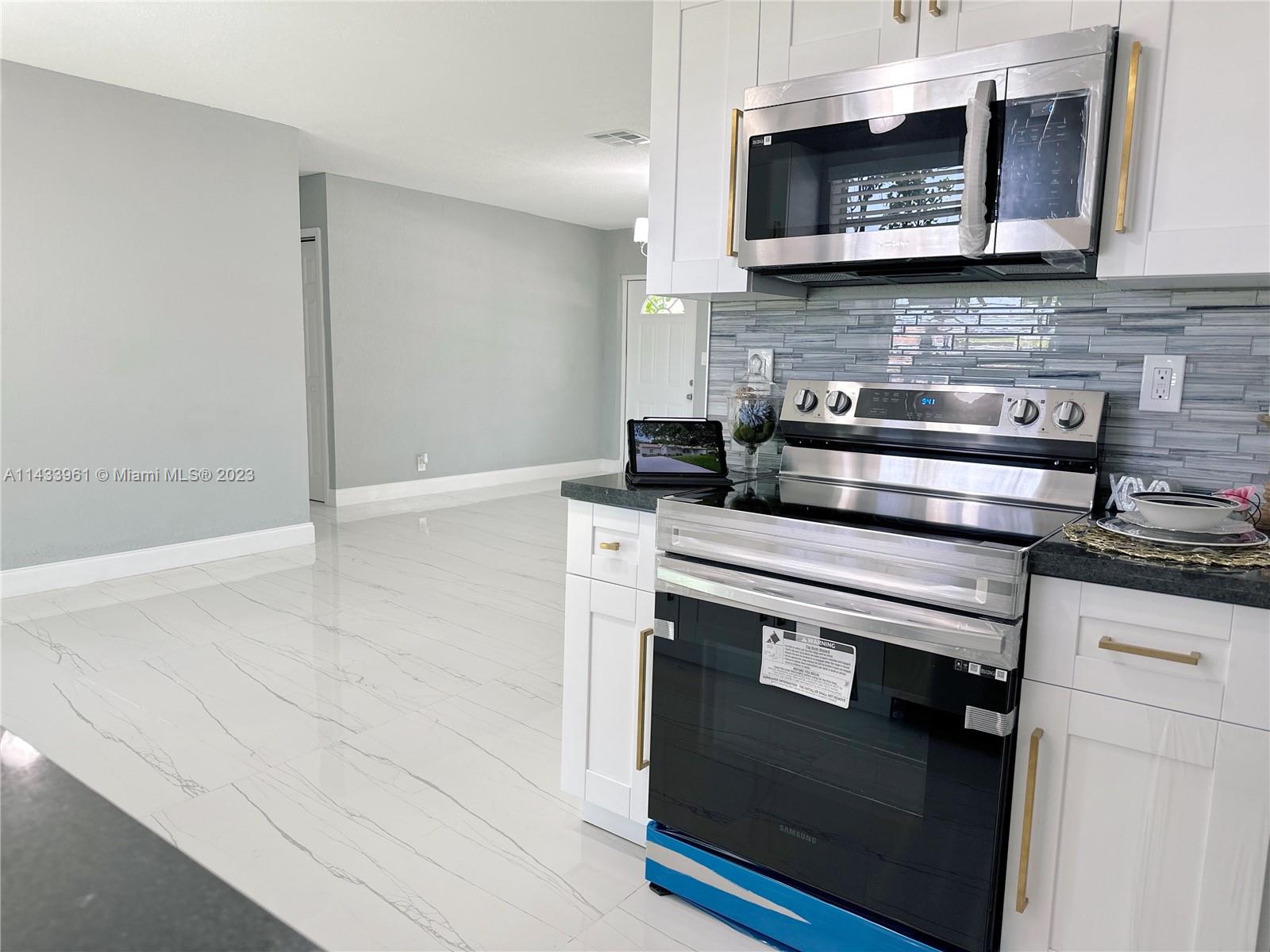 1460 Southwest 3rd Terrace Deerfield Beach, FL 33441 - Photo 32 of 100 a stove top oven sitting inside of a kitchen