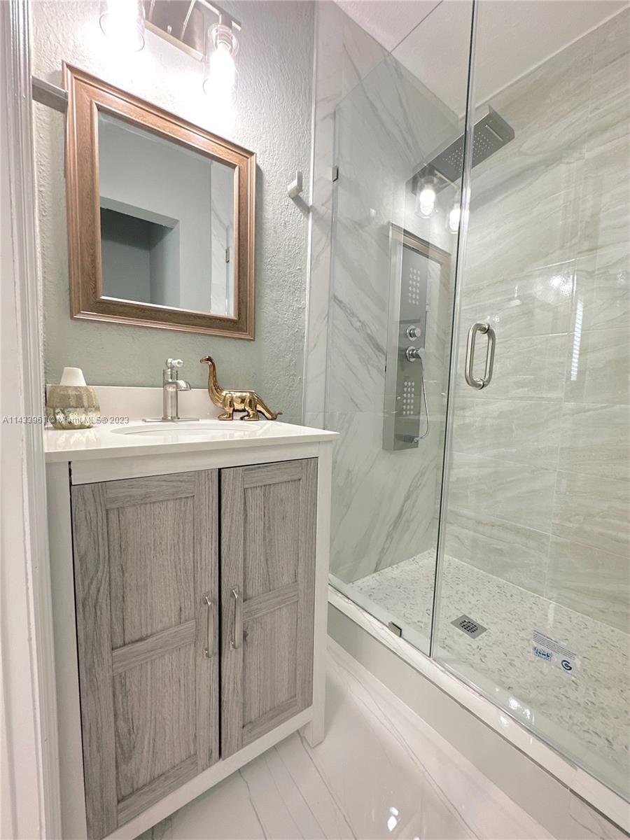 1460 Southwest 3rd Terrace Deerfield Beach, FL 33441 - Photo 54 of 100 a bathroom with a shower sink and mirror