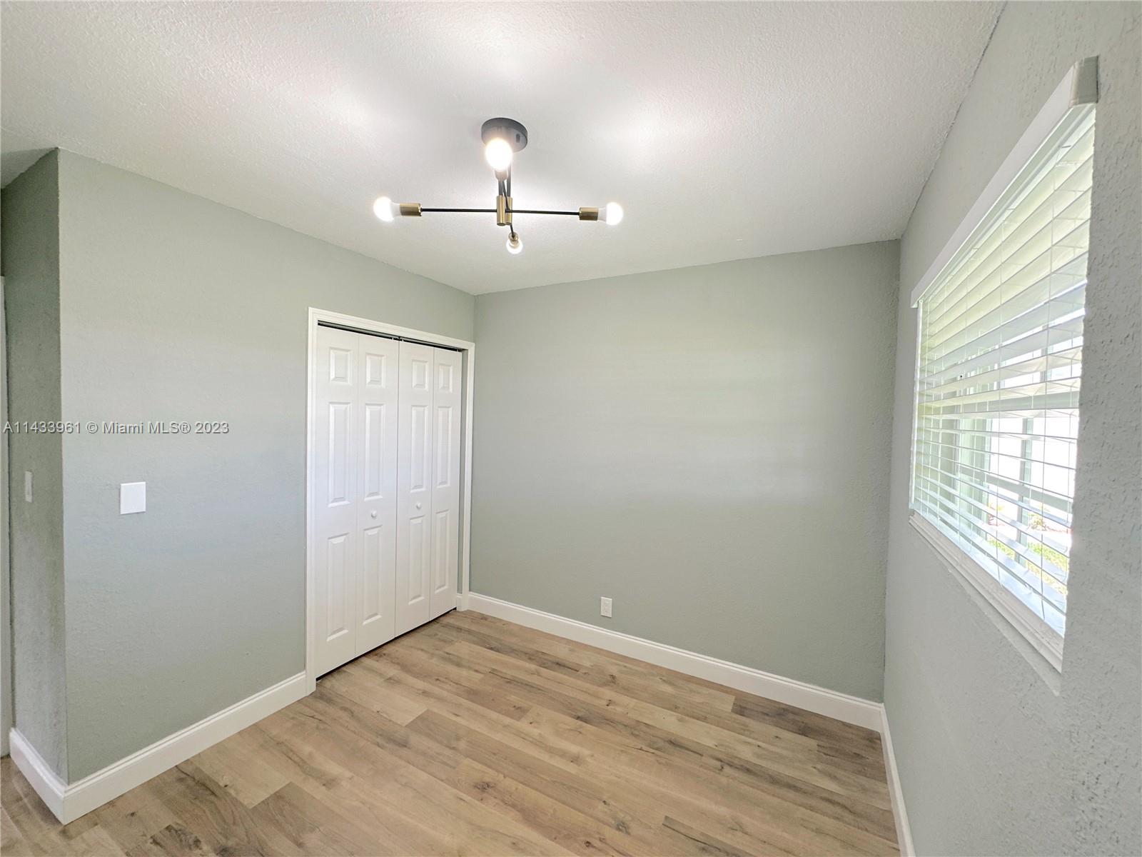 1460 Southwest 3rd Terrace Deerfield Beach, FL 33441 - Photo 57 of 100 an empty room with wooden floor and windows