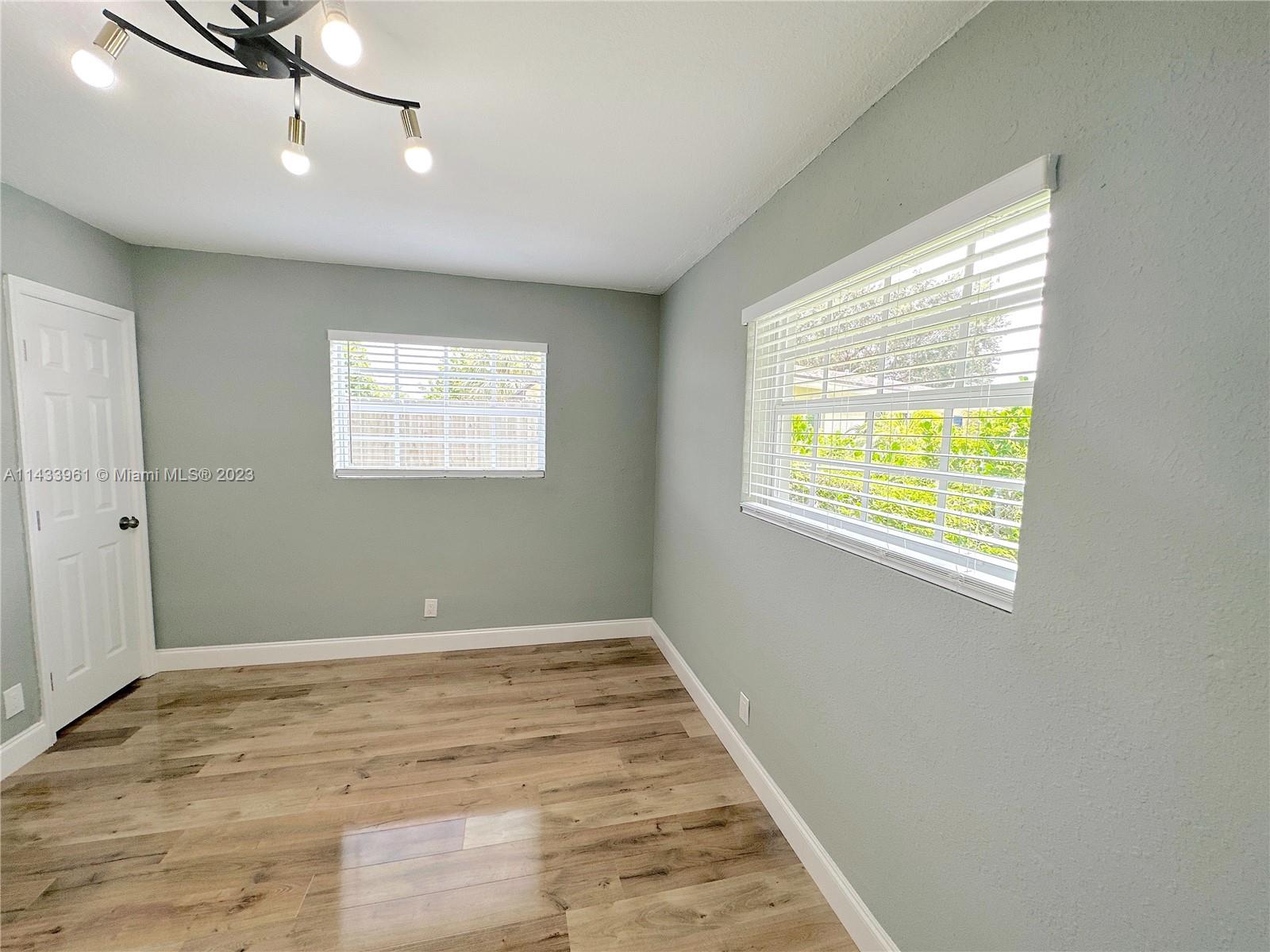 1460 Southwest 3rd Terrace Deerfield Beach, FL 33441 - Photo 66 of 100 a view of an empty room with wooden floor and a window