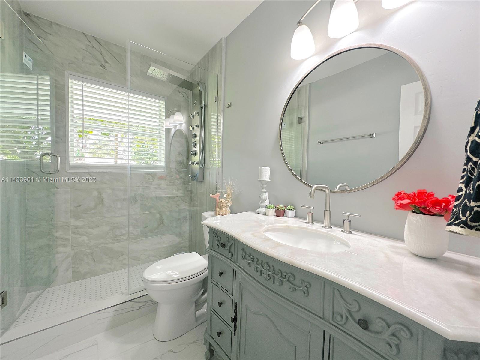1460 Southwest 3rd Terrace Deerfield Beach, FL 33441 - Photo 73 of 100 a bathroom with a toilet a sink and mirror