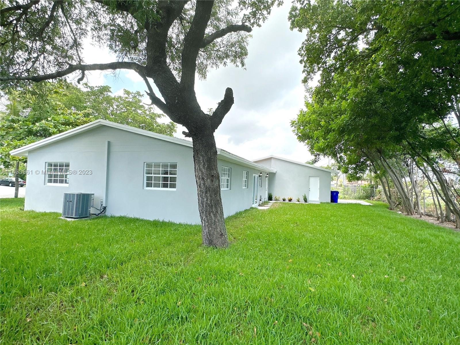 1460 Southwest 3rd Terrace Deerfield Beach, FL 33441 - Photo 81 of 100 a white house that has a tree in front of it