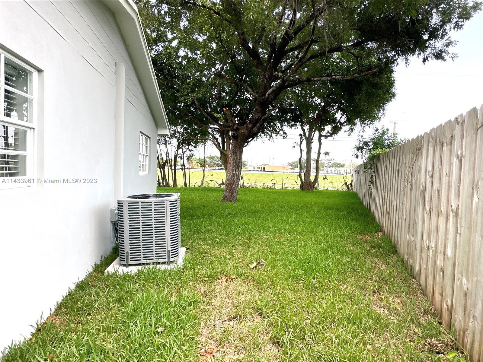 1460 Southwest 3rd Terrace Deerfield Beach, FL 33441 - Photo 84 of 100 a view of a yard with wooden fence and trees