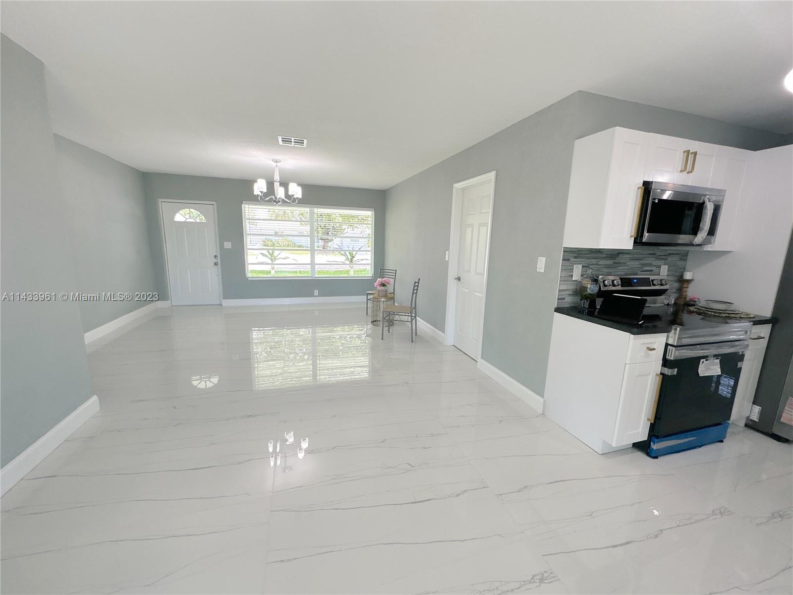 1460 Southwest 3rd Terrace Deerfield Beach, FL 33441 - Photo 9 of 100 a kitchen with a sink a microwave and cabinets
