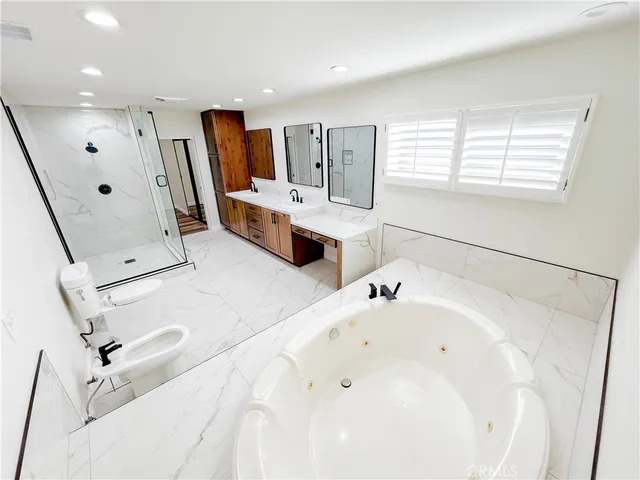 a large white tub sitting in a en suite bathroom
