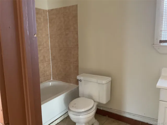 a white toilet sitting next to a bathroom sink and a shower