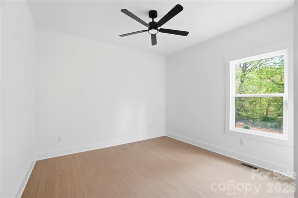 an empty room with a window and a fan