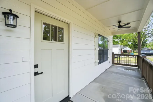 a view of a porch with wooden floor and iron gate