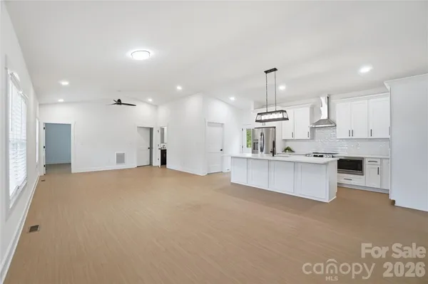 a kitchen with kitchen island white cabinets and refrigerator