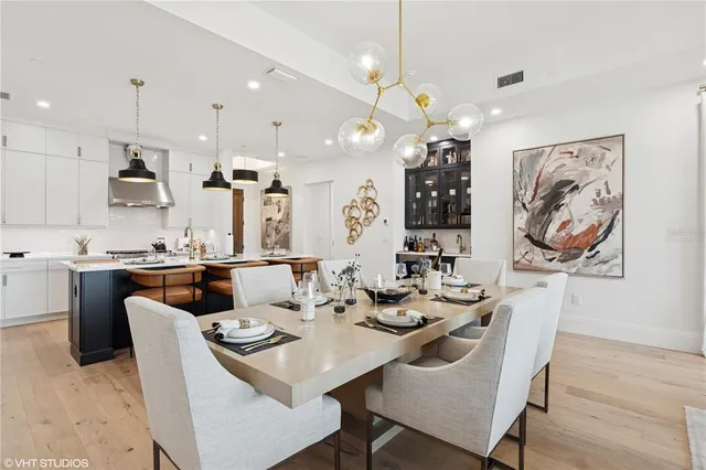 a view of a dining room with furniture a chandelier and wooden floor