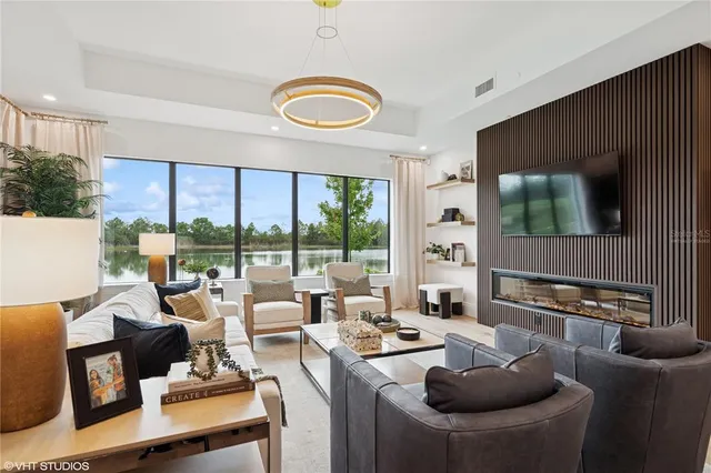 a living room with furniture kitchen view and large windows