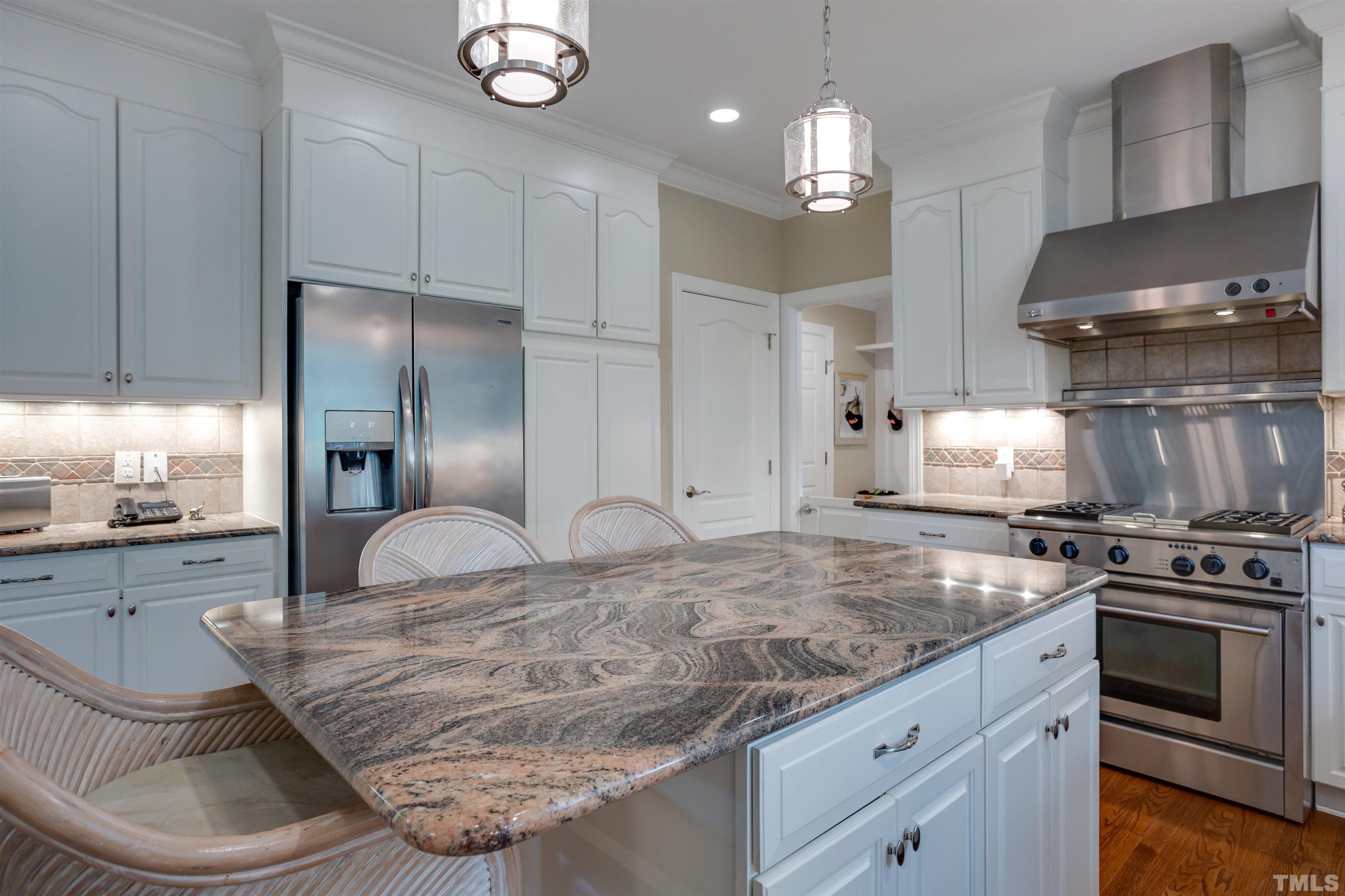 9004 Shellwood Court Raleigh, NC 27617 - Photo 11 of 30 a kitchen with kitchen island granite countertop a stove a sink and a refrigerator