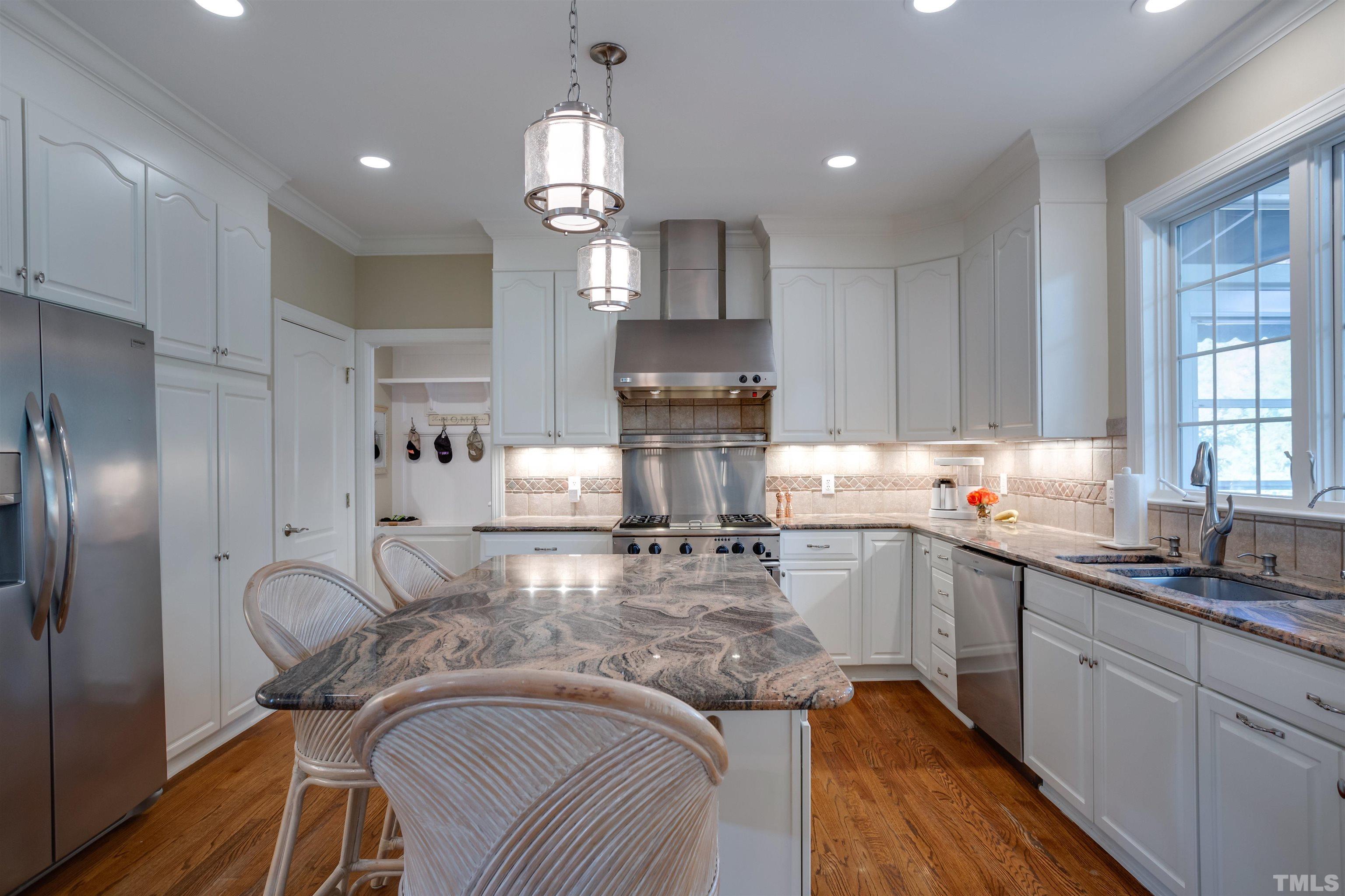 9004 Shellwood Court Raleigh, NC 27617 - Photo 10 of 30 a kitchen with kitchen island granite countertop a sink cabinets and stainless steel appliances