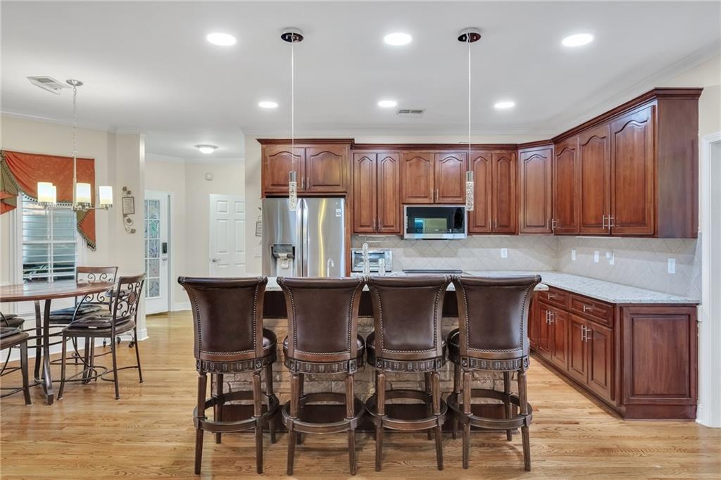 211 Graymist Path Southwest Loganville, GA 30052 - Photo 14 of 65 a kitchen with stainless steel appliances kitchen island granite countertop a table chairs sink and cabinets