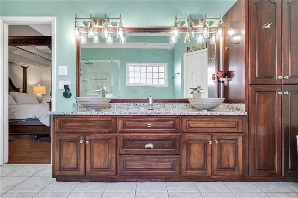 211 Graymist Path Southwest Loganville, GA 30052 - Photo 23 of 65 a bathroom with a granite countertop sink and a mirror