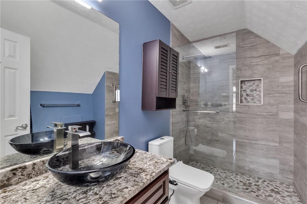 211 Graymist Path Southwest Loganville, GA 30052 - Photo 37 of 65 a bathroom with a toilet a sink and a mirror