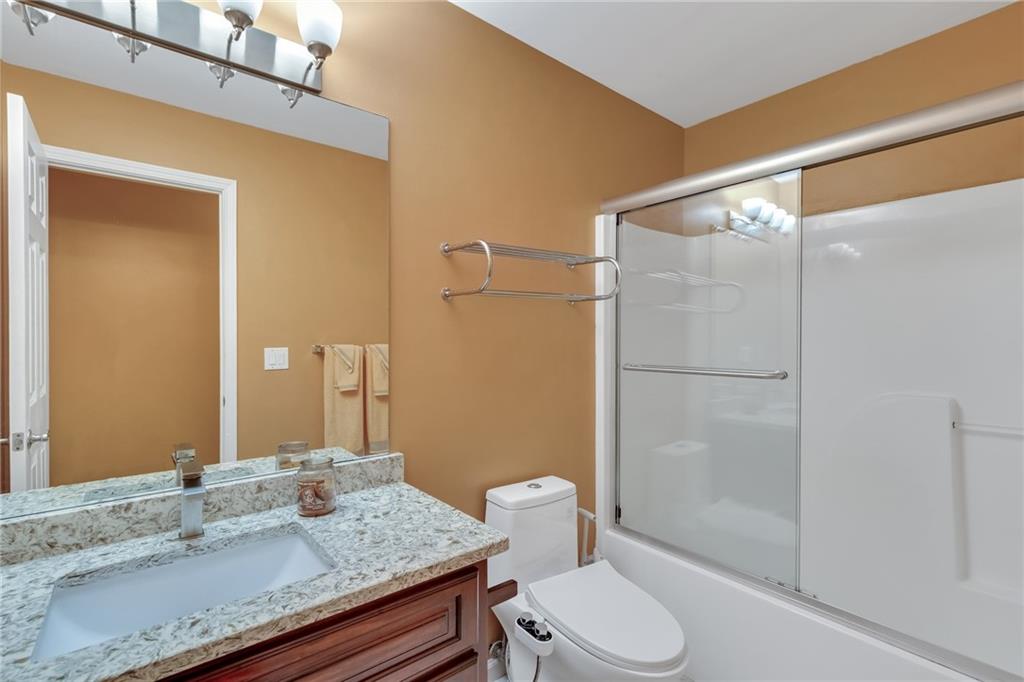 211 Graymist Path Southwest Loganville, GA 30052 - Photo 56 of 65 a bathroom with a granite countertop sink toilet and shower