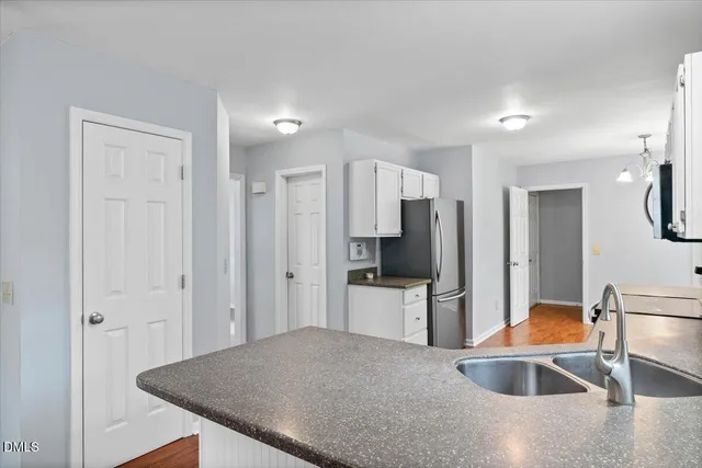 a kitchen with white cabinets and appliances