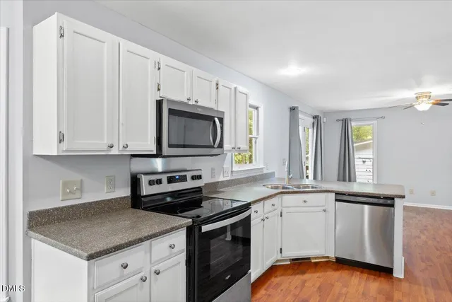 a kitchen with stainless steel appliances granite countertop a refrigerator and a stove top oven