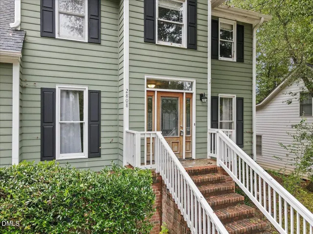 an empty room with wooden floor chandelier fan and windows