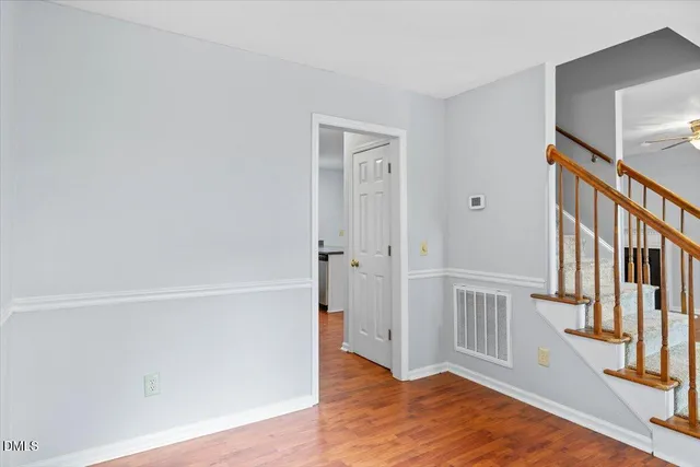 a view of an empty room with window and wooden floor
