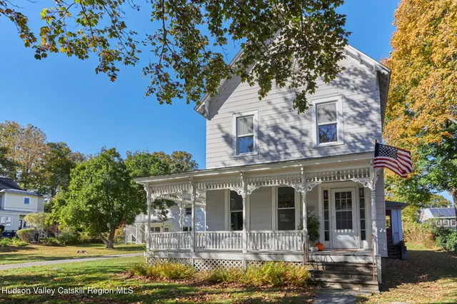 a front view of a house with a tree