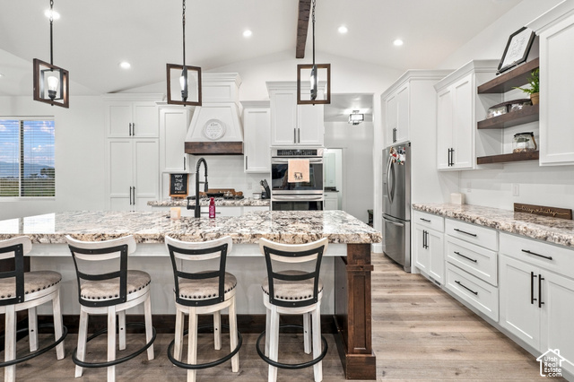 244 East Sevier River Road Central Valley, UT 84754 - Photo 22 of 66 Spacious kitchen featuring an expansive center island with seating, white cabinetry, built-in stainless steel appliances, and wood-finish flooring