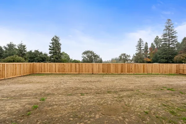 a view of a yard with wooden fence