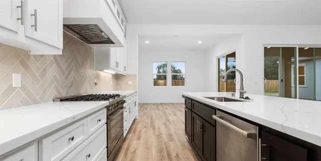 a kitchen with a sink stove and cabinets