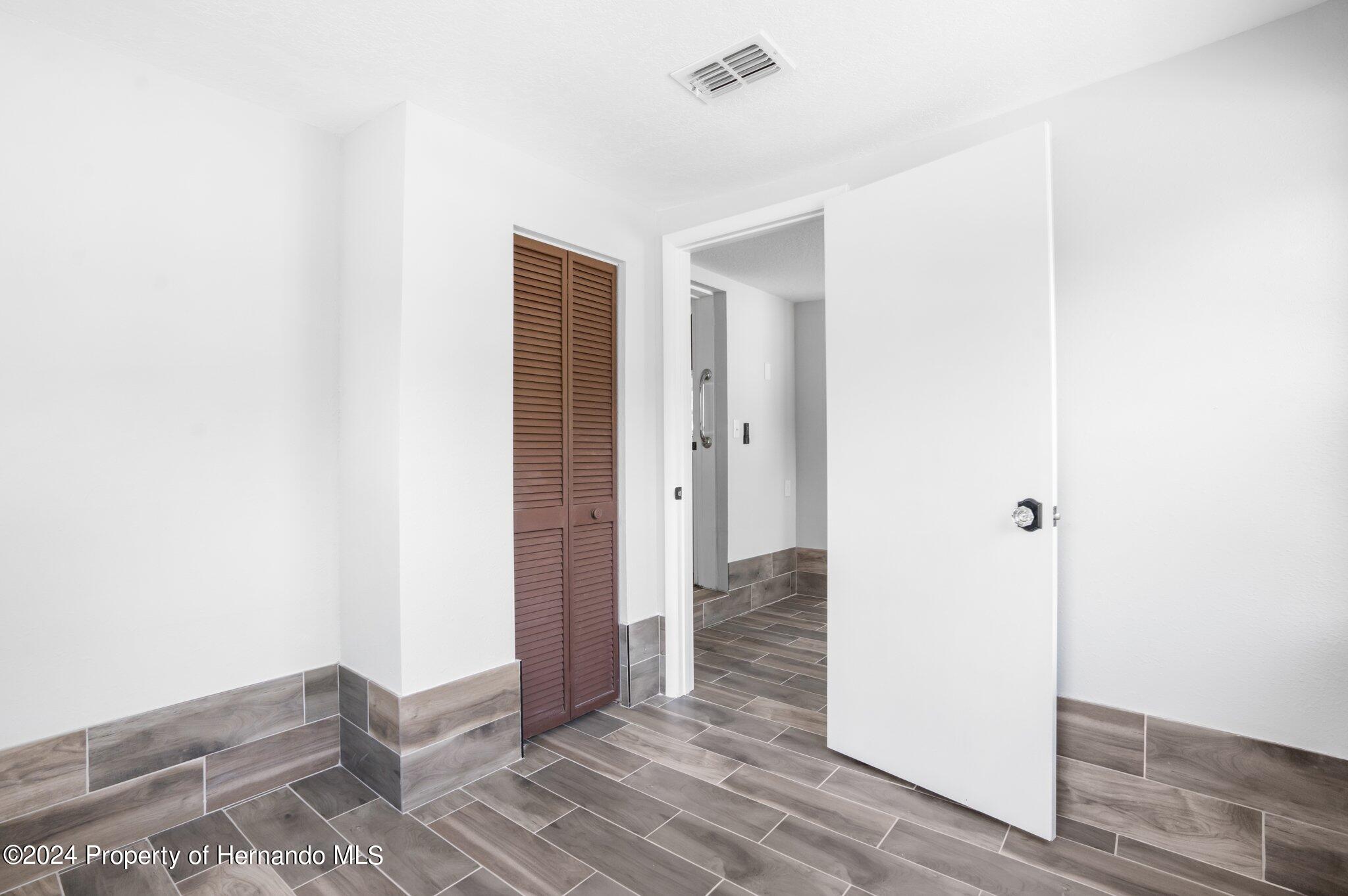 5411 Teal Drive Weeki Wachee, FL 34607 - Photo 14 of 40 a view of a room with wooden floor