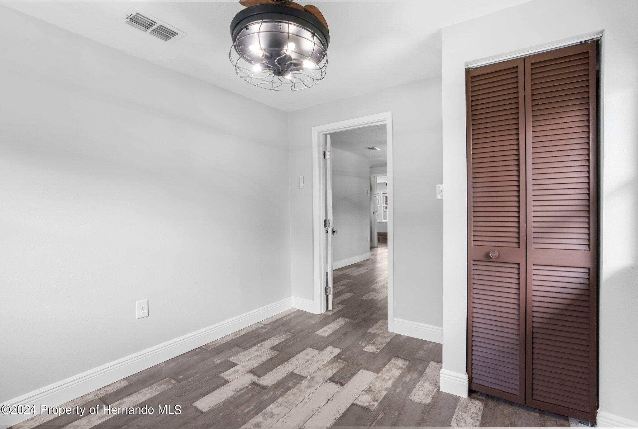 5411 Teal Drive Weeki Wachee, FL 34607 - Photo 19 of 40 a view of empty room with wooden floor and fan