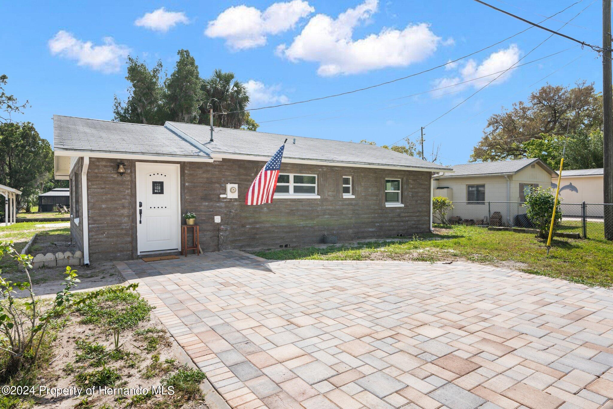5411 Teal Drive Weeki Wachee, FL 34607 - Photo 21 of 40 a front view of a house with a yard and garage