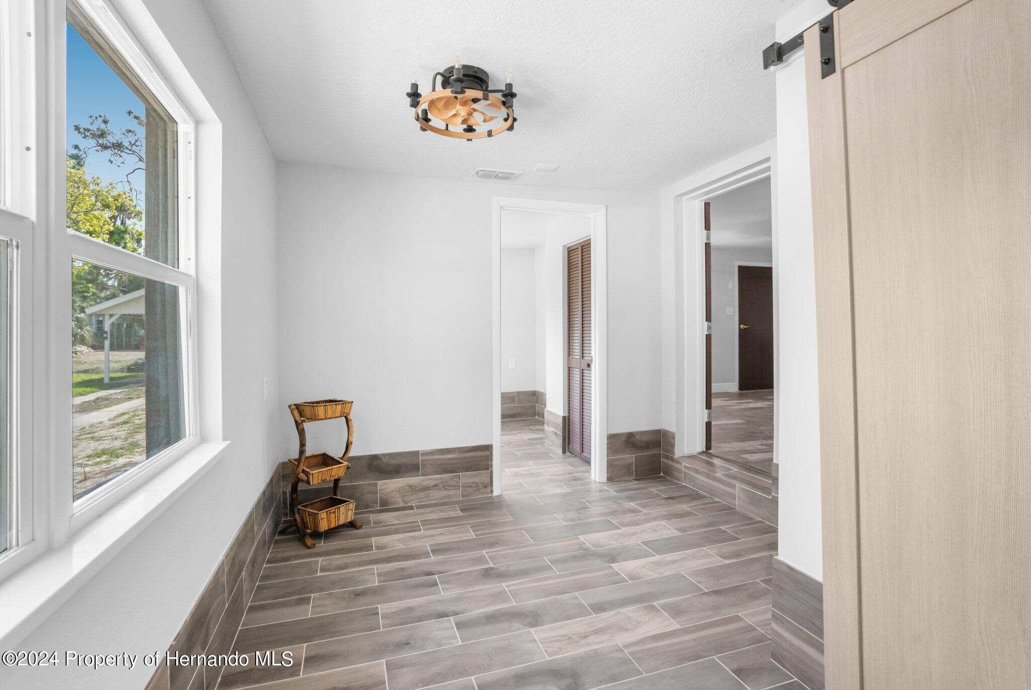 5411 Teal Drive Weeki Wachee, FL 34607 - Photo 29 of 40 a view of empty room with wooden floor and fan