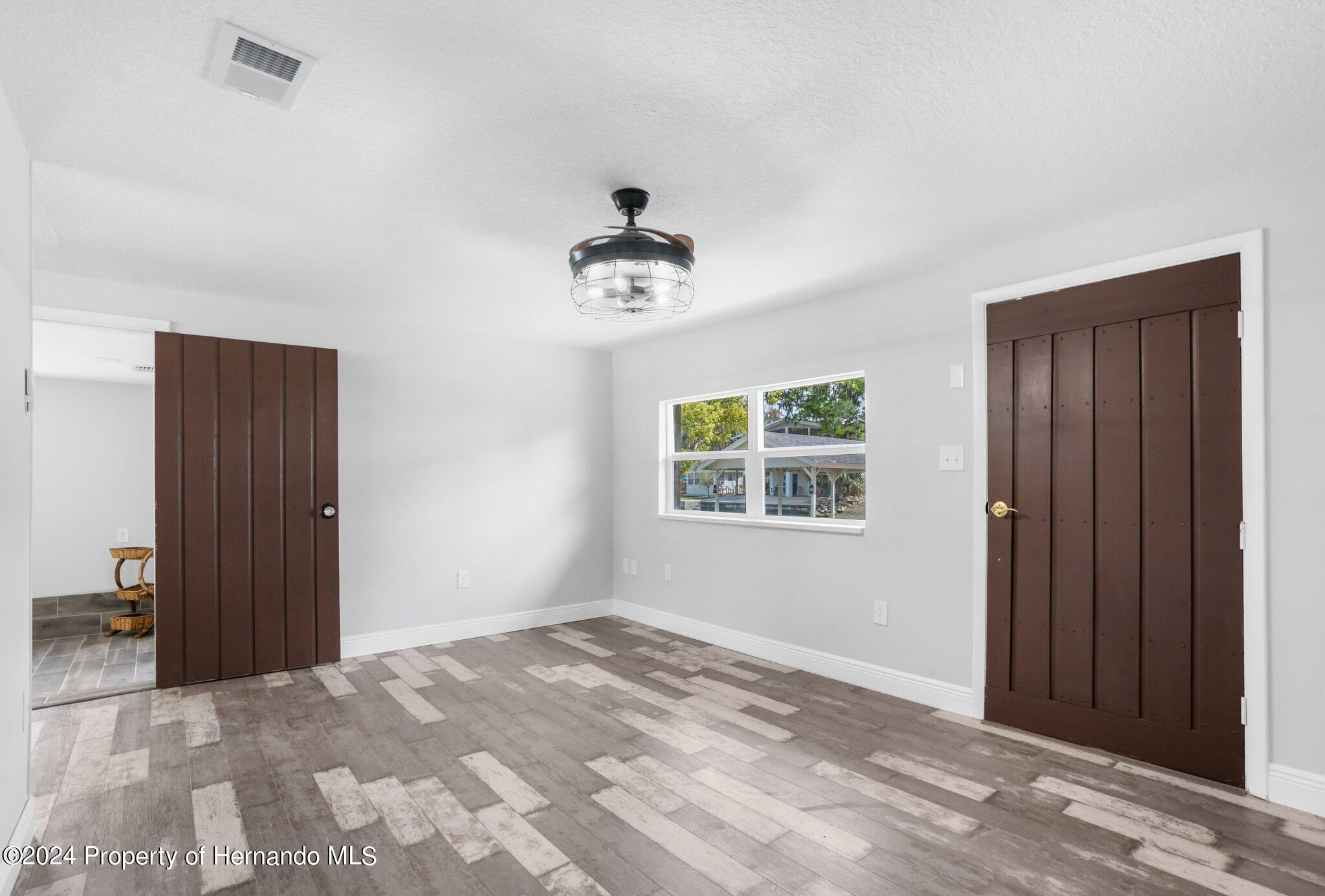 5411 Teal Drive Weeki Wachee, FL 34607 - Photo 5 of 40 wooden floor in an empty room with a window