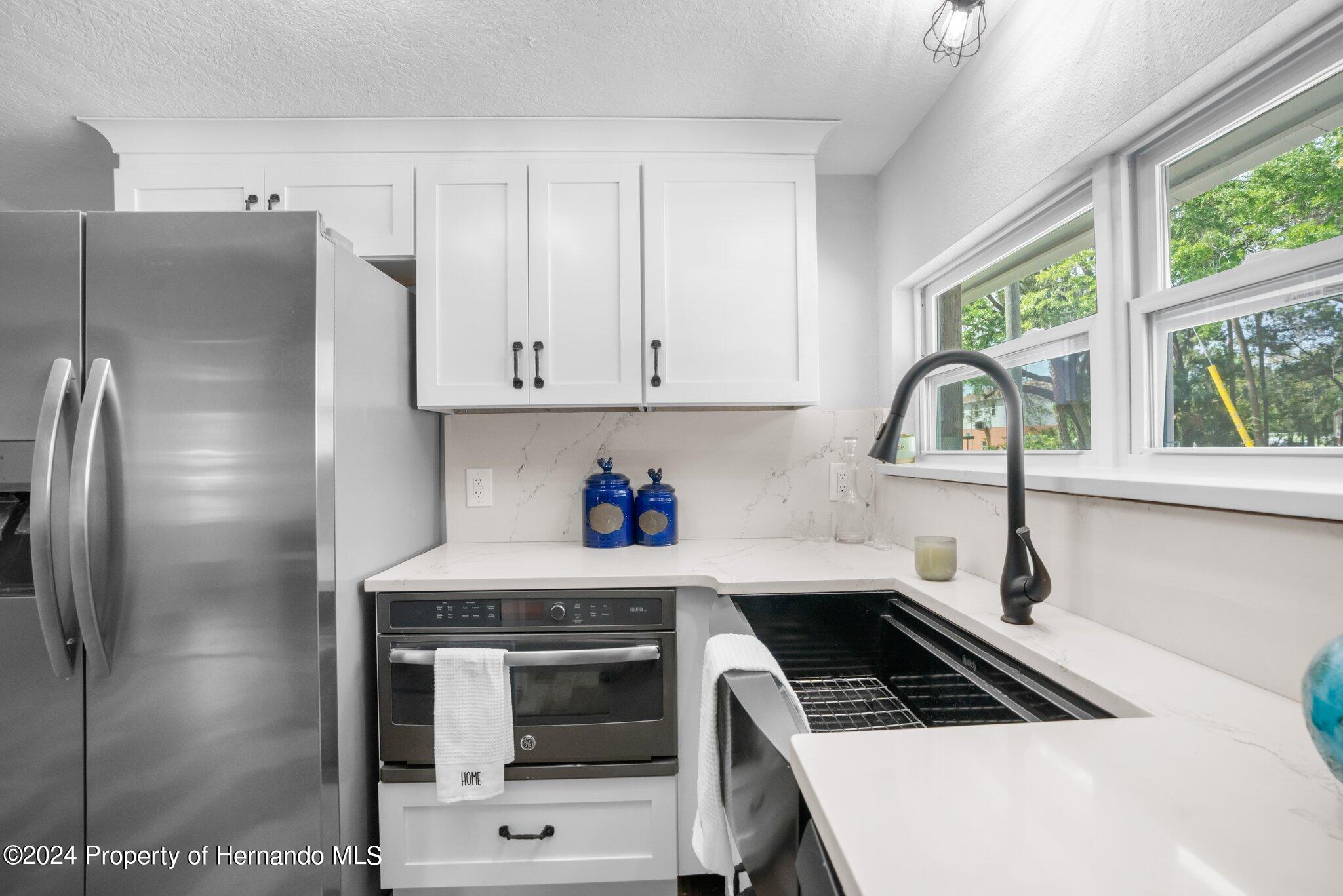 5411 Teal Drive Weeki Wachee, FL 34607 - Photo 8 of 40 a kitchen with granite countertop a stove a sink and a refrigerator