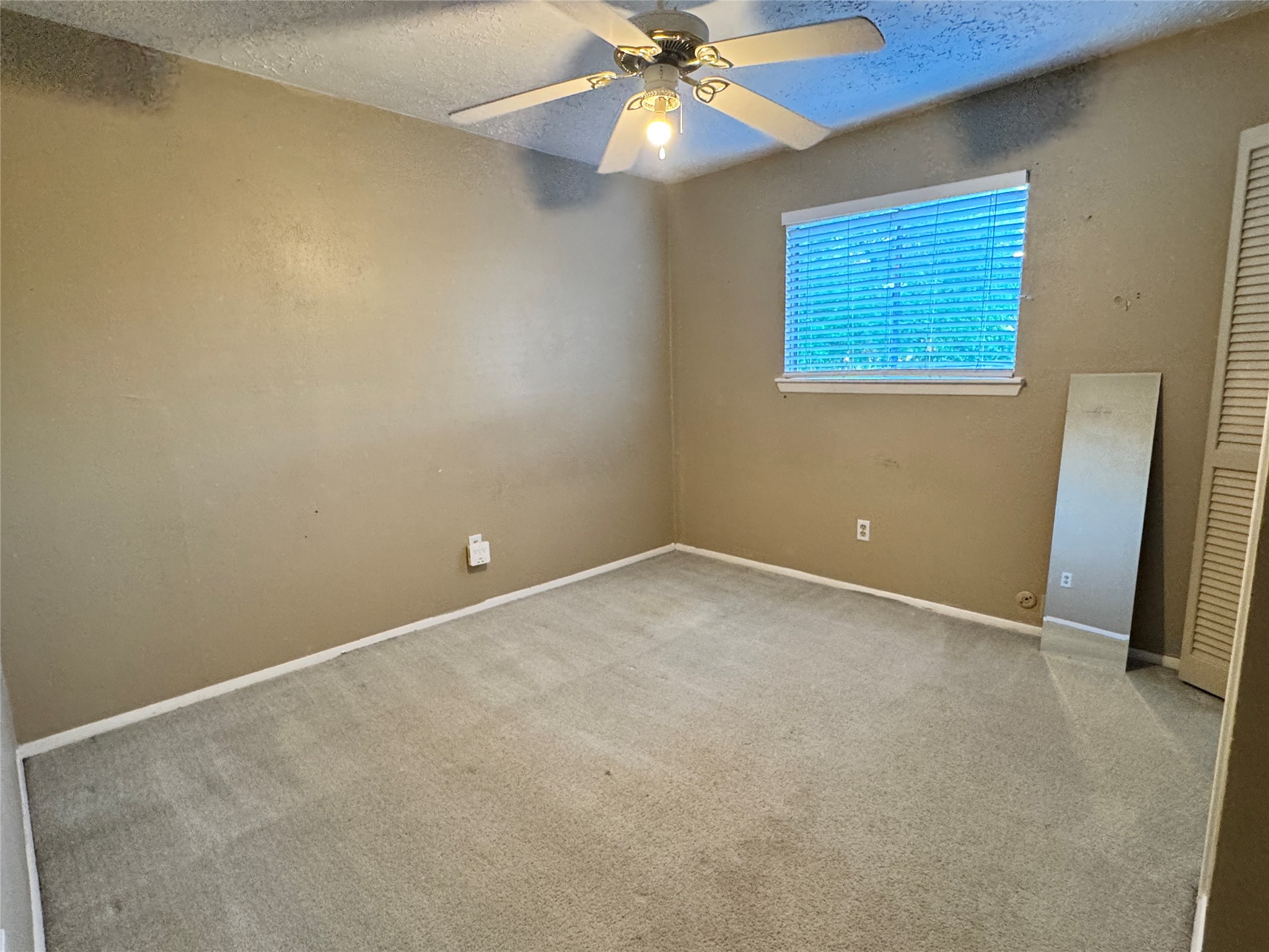 8519 Church Light Lane Houston, TX 77064 - Photo 13 of 24 an empty room with a ceiling fan and a window