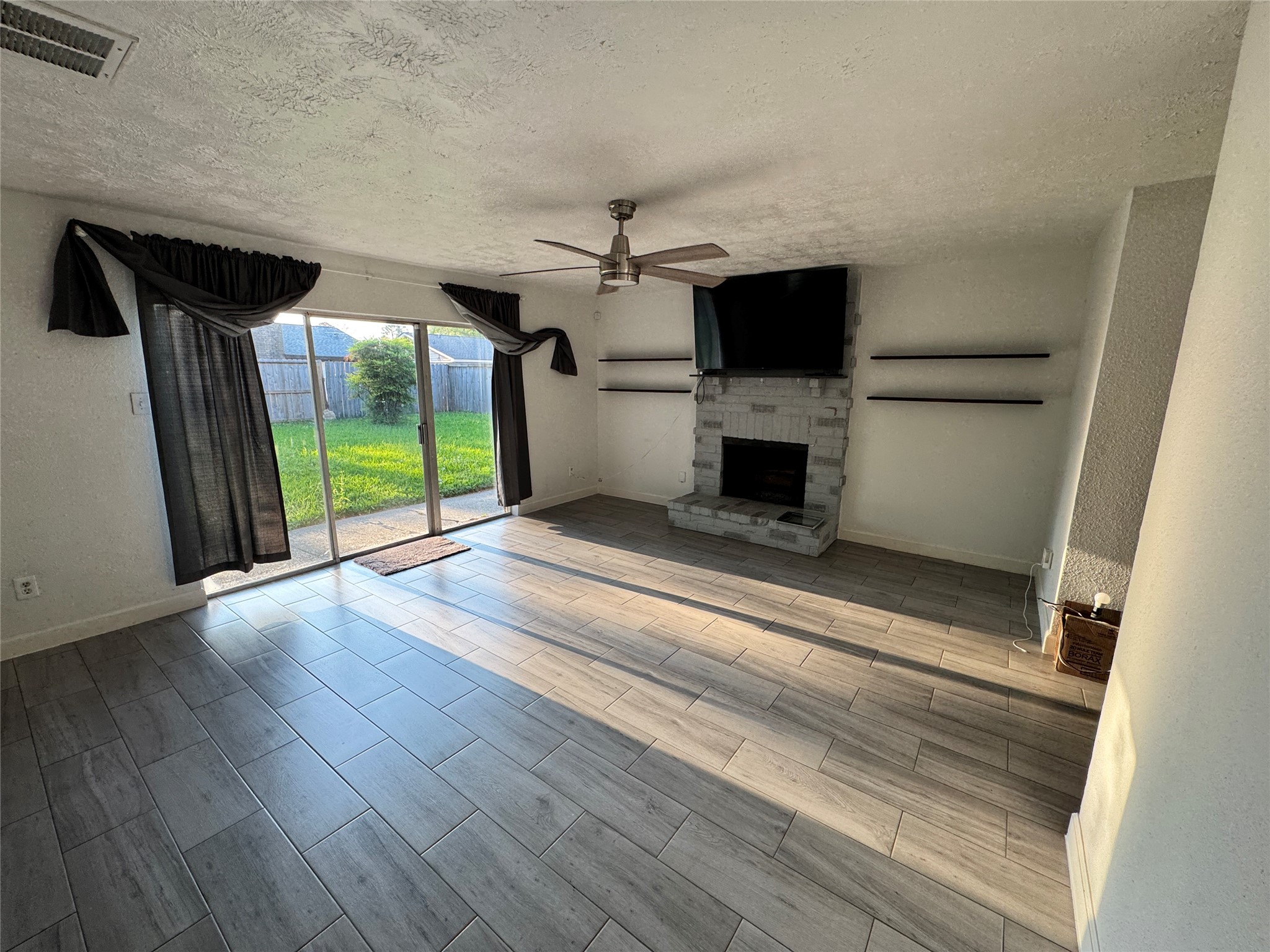8519 Church Light Lane Houston, TX 77064 - Photo 3 of 24 wooden floor in an empty room with a fireplace