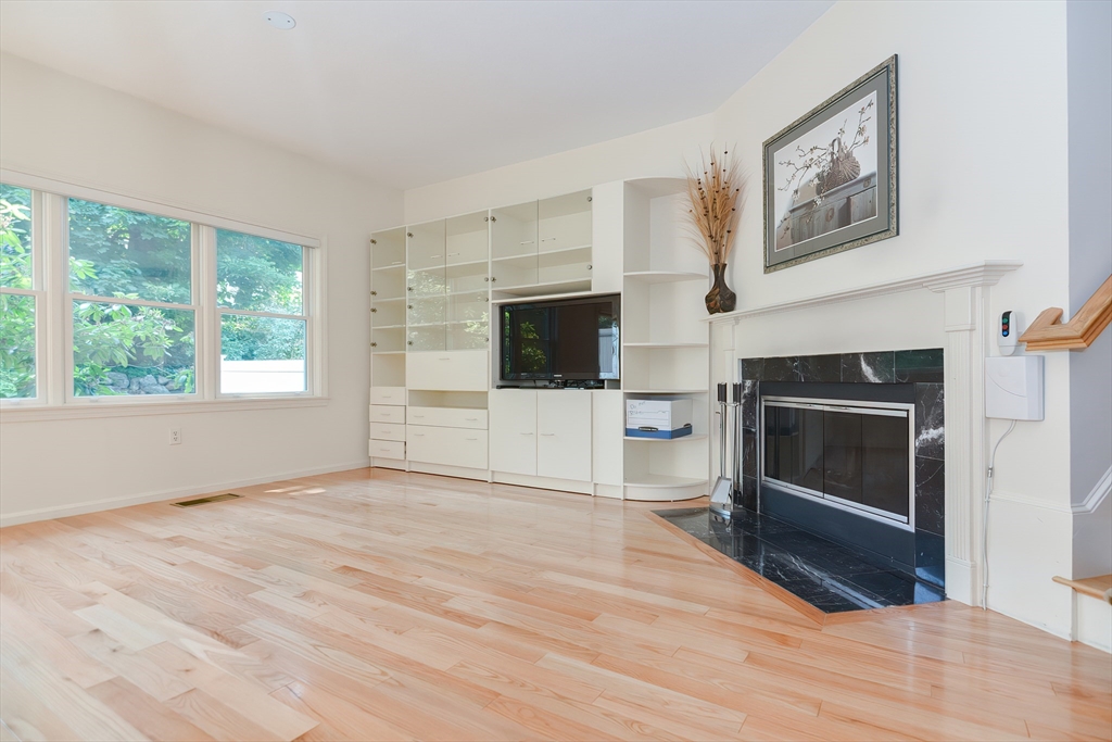 327 Bishops Forest Drive, Unit 327 Waltham, MA 02452 - Photo 16 of 38 a view of an empty room with a fireplace and a window