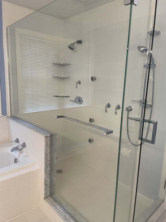 327 Bishops Forest Drive, Unit 327 Waltham, MA 02452 - Photo 23 of 38 a bathroom with a bathtub and a shower