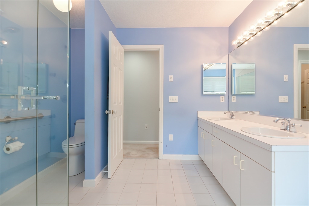 327 Bishops Forest Drive, Unit 327 Waltham, MA 02452 - Photo 25 of 38 a bathroom with a double vanity sink toilet and shower