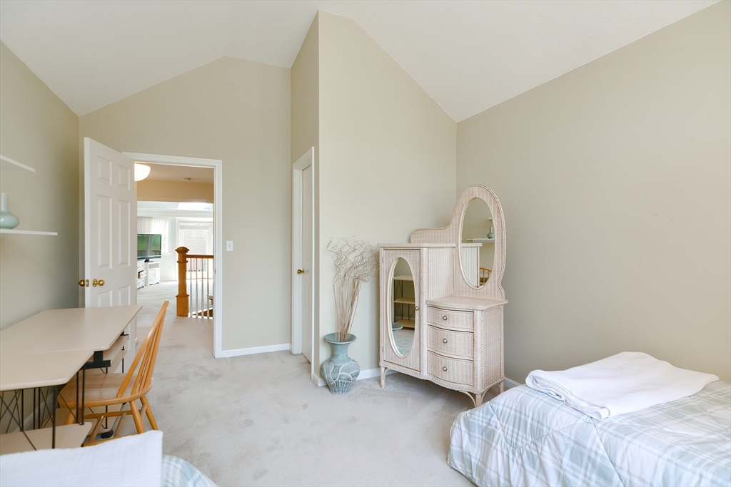 327 Bishops Forest Drive, Unit 327 Waltham, MA 02452 - Photo 27 of 38 a bedroom with a bed and a table in it