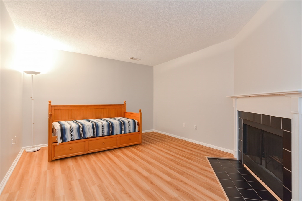 327 Bishops Forest Drive, Unit 327 Waltham, MA 02452 - Photo 29 of 38 a bedroom with a bed and wooden floor