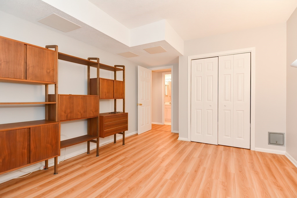 327 Bishops Forest Drive, Unit 327 Waltham, MA 02452 - Photo 32 of 38 a view of a bedroom with wooden floor and a window
