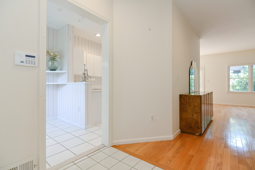 327 Bishops Forest Drive, Unit 327 Waltham, MA 02452 - Photo 4 of 38 wooden floor in an empty room with a window