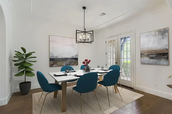 a dining room with furniture potted plants and wooden floor