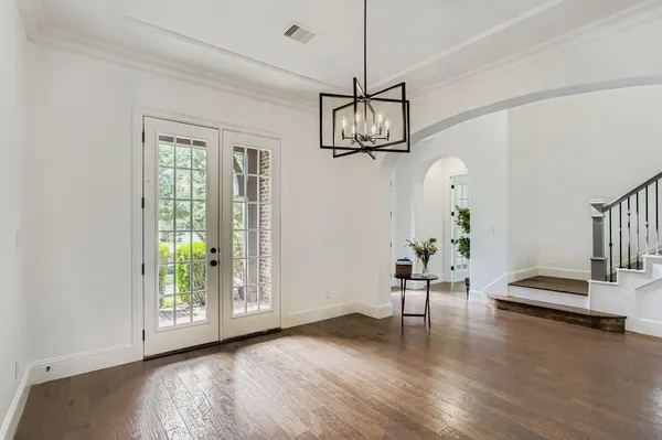 a view of a livingroom with wooden floor and a chandelier