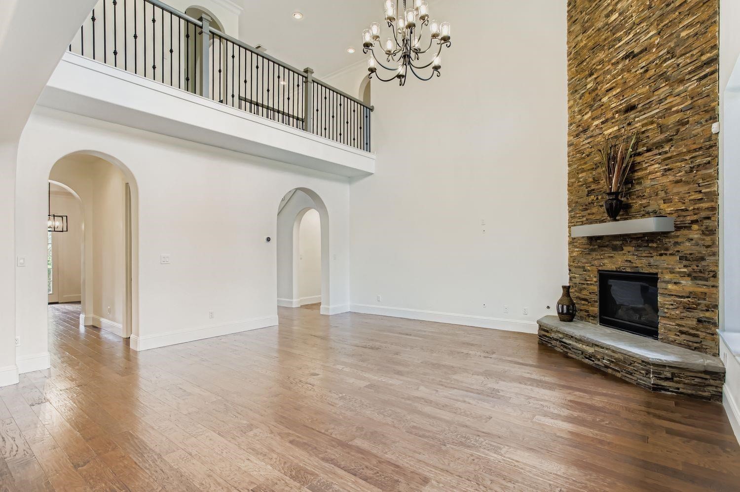 6 Freestone Stream Place The Woodlands, TX 77389 - Photo 14 of 50 a view of a livingroom with a fireplace wooden floor and a chandelier