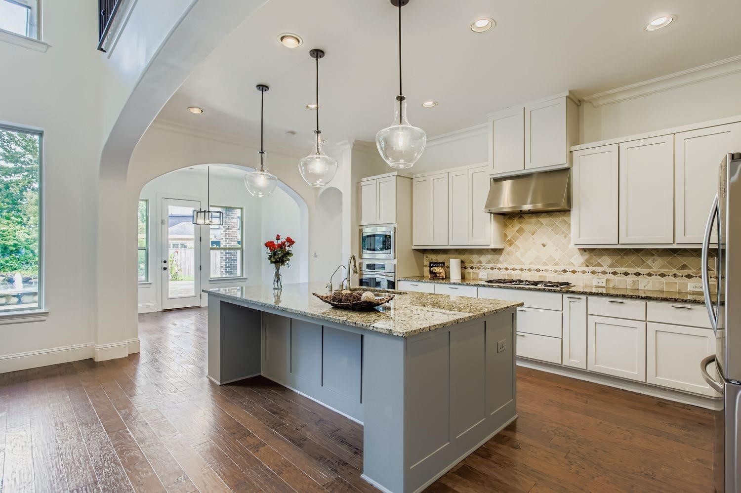 6 Freestone Stream Place The Woodlands, TX 77389 - Photo 19 of 50 a kitchen with stainless steel appliances granite countertop a sink a stove and a wooden floor