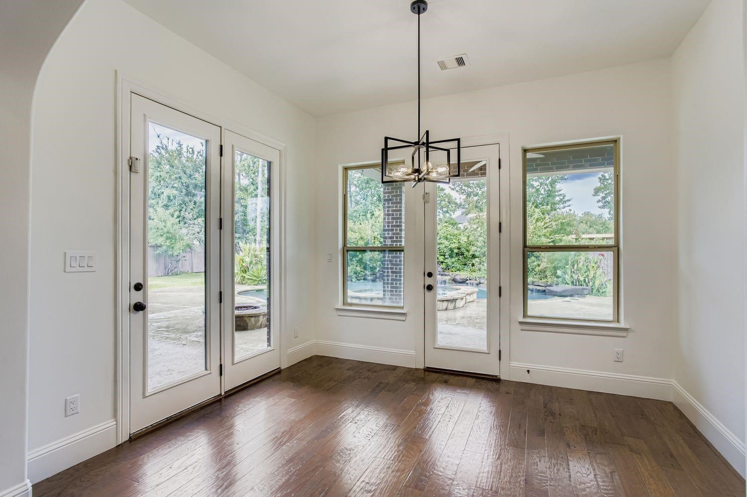 6 Freestone Stream Place The Woodlands, TX 77389 - Photo 20 of 50 a view of an empty room with wooden floor exposed radiator and windows